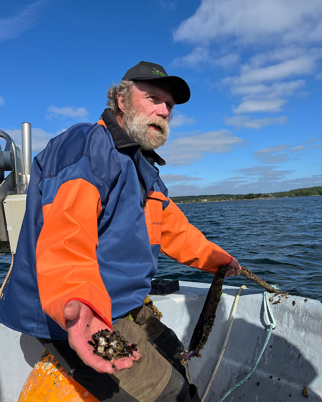 Fiskaren Glenn Fridhvisar upp små musslor som odlas i havet.